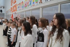 Szkolny chór Tu-Tu przewodzi wspólnemu śpiewaniu hymnu.