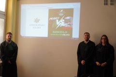 Trójka adwokatów na tle prezentacji.