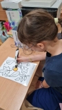 Dziewczynka koloruje żołędzia długopisem 3D.