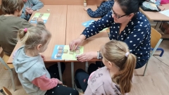 Nauczycielka wyjaśnia uczennicom zasady gry Złapmy Lwa.