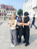 Trzech uczniów stoi jeden za drugim używając pleców osoby stojącej przed jako stolika do pisania rozwiązań.