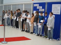 Grupa nagrodzonych stypendystów z klas 7-8 na tle dekoracyjnej ścianki.