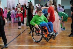 Chłopiec siedzący na wózku inwalidzkim uczestniczy w muzycznej zabawie.