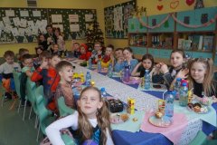 Zdjęcie grupowe Uczniów klasy 1c. Przy stole siedzą Dzieci przebrane m.in. za superbohaterów i księżniczki.