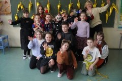 Zdjęcie grupowe Uczniów klasy 3a. Na tle karnawałowej dekoracji stoją Dzieci przebrane m.in. za króla, drapieżniki i czarodziejów.