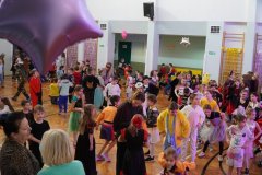 Dzieci z różnych klas podczas zabaw tanecznych na sali gimnastycznej.