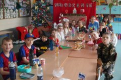  Zdjęcie grupowe Uczniów klasy 2d. Na tle karnawałowej dekoracji stoją Dzieci przebrane m.in. za policjanta, dinozaura, tancerzy i postacie z gier.