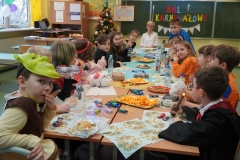 Uczniowie klasy 2e wraz z wychowawczynią przy stole zastawionym przekąskami.