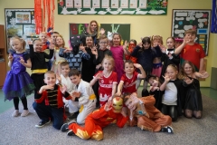 Grupowe zdjęcie klasy 1b wraz z wychowawczynią w strojach karnawałowych.
