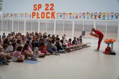 Forum szkoły. Ratownik WOPR obrazuje użycie ratowniczej bojki pływackiej.
