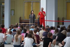 Uczniowie klas piątych, szóstych i siódmych siedząc na forum szkoły słuchają wykładu o bezpieczeństwie podczas wakacyjnych zabaw w wodzie. Zajęcia  prowadzi ratownik płockiego WOPR, p. Andrzej Rutkowski.