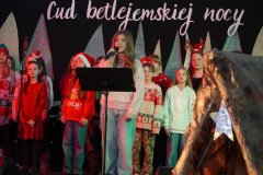 Solistka śpiewa kolędę. W tle widać chór TuTu.