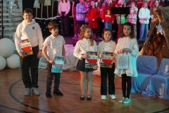 Widzimy dzieci nagrodzone w szkolnym konkursie rodzinnych szopek bożonarodzeniowych.