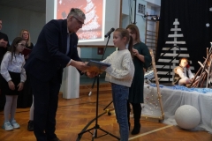 Pan Dyrektor wręcza nagrody uczniom, którzy zdobyli czołowe miejsca w konkursie "Rodzinnych Szopek Bożonarodzeniowych".