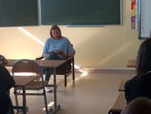 Mama jednej z uczennic siedzi na fotelu i czyta uczniom klasy 7g wybrany fragment literatury młodzieżowej. 