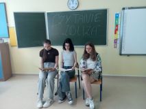 Na tle dekoracji pod hasłem ,,Czytanie zbliża’’ trzy uczennice czytają dzieciom z klasy 4f fragmenty literatury dziecięcej.