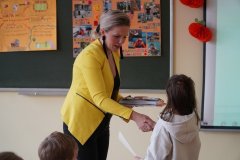 Zdjęcie przedstawia nauczyciela wręczającego nagrodę w konkursie.
