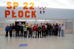 Grupa kilkunastu Najbardziej Koleżeńskich Cholpaków z klas 4-8 wraz z przedstawicielkami Samorządu uczniowskiego na tle gazetki, ustawionej na forum szkoły.