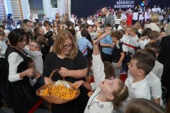  Wicedyrektor Szkoły- p. Monika Przemyłska, ubrana w czarną bluzkę, przechodzi z koszykiem pełnym cukierków wśród Uczniów. 