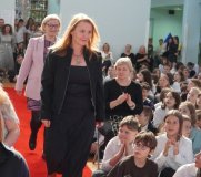 Na tle dzieci biorących udział w akademii, czerwonym dywanem idą po odbiór nagrody Dyrektora panie Magdalena Wilicka i Magdalena Krukowska.