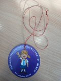 Medal z fioletowym tłem, z napisem „Najsympatyczniejsza dziewczyna w klasie – rok szkolny 2025/2026” przewleczony czerwonym, brokatowym sznurkiem.