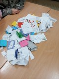 Drewniana ławka szkolna pokryta dużą liczbą kolorowych i białych karteczek – pozdrowień i życzliwych wiadomości wyjętych ze Skrzynki Życzliwości. 