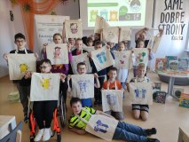 Grupa dzieci pozuje do zdjęcia z ozdobionymi ekotorbami. 