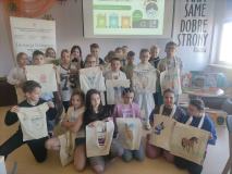 Grupa dzieci pozuje do zdjęcia z ozdobionymi ekotorbami.