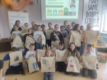 Grupa dzieci pozuje do zdjęcia z ozdobionymi ekotorbami.