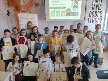 Grupa dzieci pozuje do zdjęcia z ozdobionymi ekotorbami.