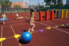 Sportowe aktywności dla dzieci na boisku szkolnym - bieg z pokonywaniem przeszkód. 