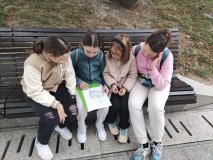 Grupa dzieci rozwiązuje zadanie zaznaczając na mapce miasta położone nad Wisłą.