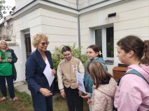 Dyrektor Książnicy Płockiej wręcza dyplom grupie dzieci uczestniczącej w grze miejskiej. 