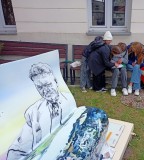 Grupa dzieci rozwiązuje zagadkę w ogrodzie Książnicy Płockiej.