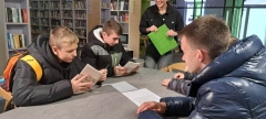Grupa chłopców rozwiązujących na kartce jedno z zadań gry.
