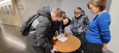 Grupa chłopców rozwiązujących na kartce jedno z zadań gry.