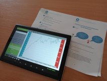 foto_4 Blat ławki szkolnej, a  na nim uruchomiony tablet z wytworzonym w odpowiednim programie wykresem prezentującym pomiar promieniowania UV
