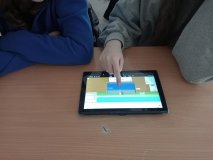 foto_5 Dwie uczennice dokonujące na tablecie symulacji fizycznych dotyczących gęstości i siły wyporu