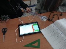 foto_6 Uczniowie prowadzą doświadczenie dotyczące przewodnictwa elektrycznego różnych substancji – za pomocą tabletów i nowoczesnych czujników mierzą, które materiały przewodzą ładunki elektryczne, pracując w grupach w szkolnej sali lekcyjnej