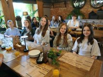 Przy dwóch restauracyjnych stołach siedzą uczestnicy Koła SU, wszyscy w pogodnych nastrojach.