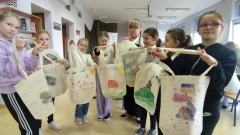 Dzieci prezentują ozdobione przez siebie torby na zakupy.