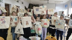 Dzieci prezentują ozdobione przez siebie torby na zakupy.