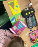 Uczniowie wykonują kartki świąteczne z materiałów papierniczych.