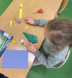 Uczniowie wykonują kartki świąteczne z materiałów papierniczych.