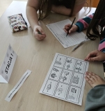 Dzieci rozwiązują przygotowane wiosenne rebusy.