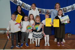 Wspólne zdjęcie nauczycieli i laureatów konkursu plastycznego w kategorii klas pierwszych, drugich i trzecich. 