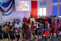 Grupa dzieci ogląda fragment filmu o królu Maciusiu.