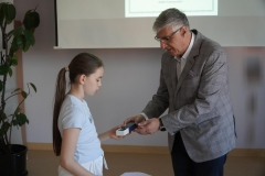 Pan Dyrektor wręcza główną nagrodę, wieczne pióro koloru niebieskiego z grawerem, uczennicy klasy trzeciej za zajęcie I miejsca.