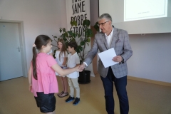 Pan Dyrektor wręcza dyplom za udział w Konkursie Ortograficznym uczennicy klasy trzeciej.