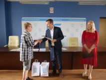 Laureat konkursu odbiera nagrodę z rąk organizatora.